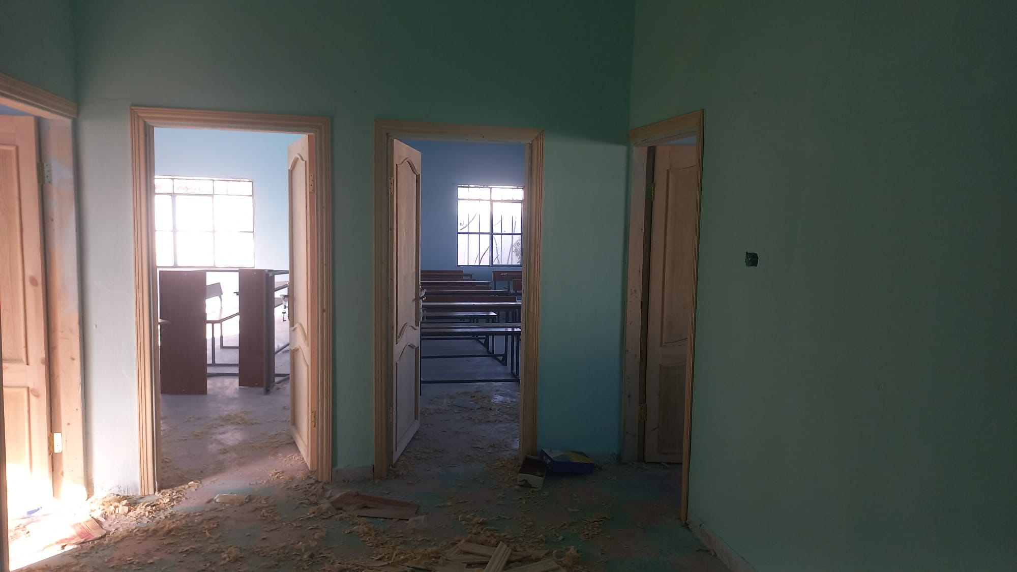 Frisch gestrichener Flur mit neuen Holztüren, Blick in zwei Klassenzimmer